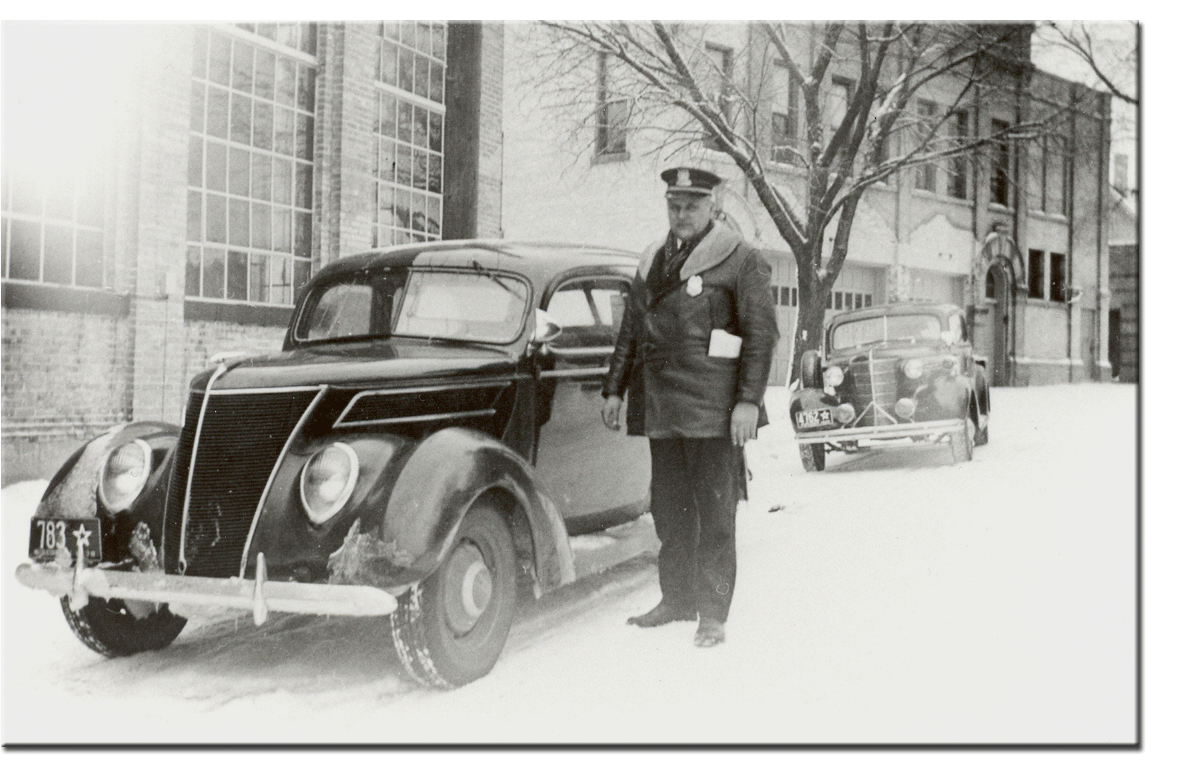 Police Chief August Frank next to Cedarburg Police Dept. squad car in front of the old power plant on Mequon Ave – Date Unknown